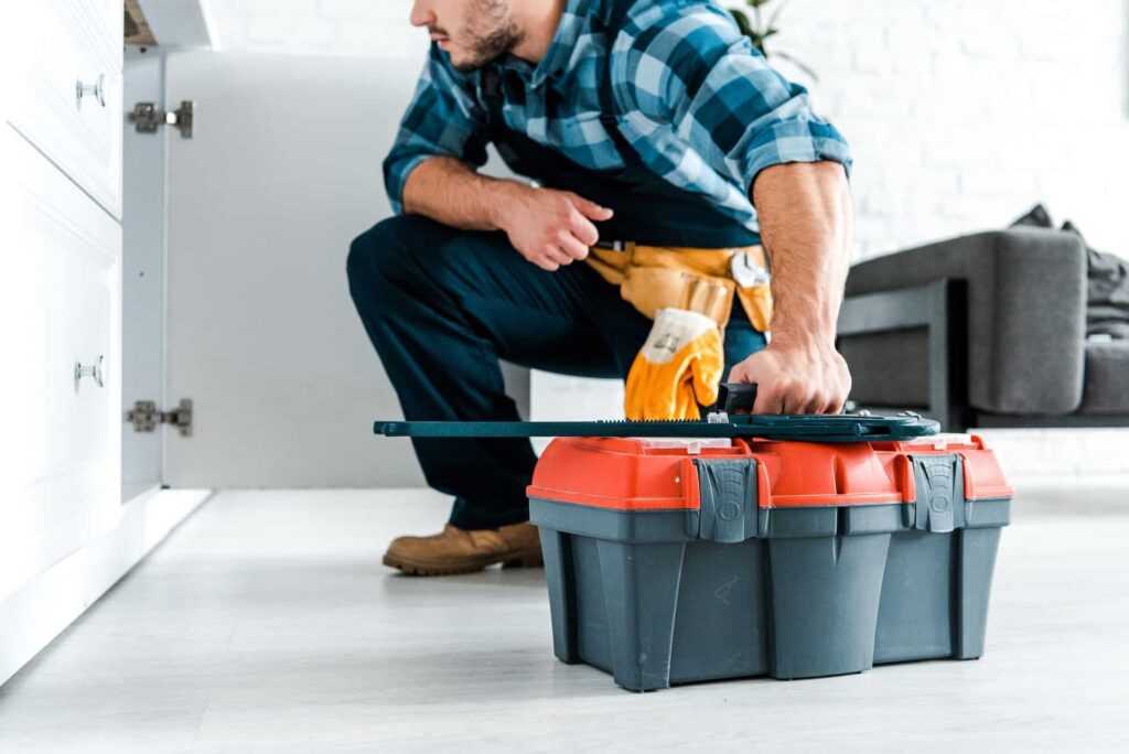 cropped-view-of-bearded-handyman-sitting-and-holding-toolbox
